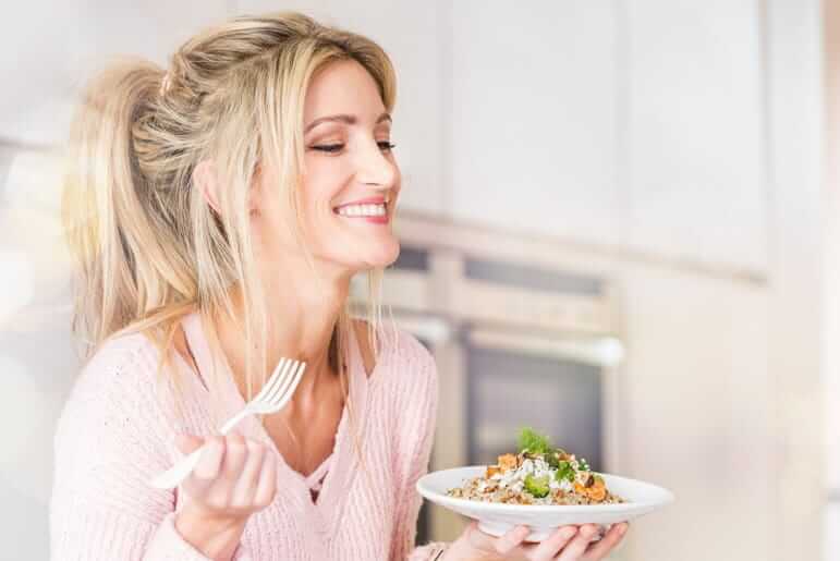 Bosto - vrouw met vork en bord met bruine rijst, zalm, broccoli